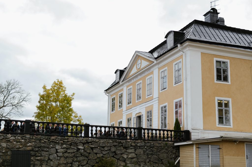Herrg&aring;rdens gula fasad med terrassen och stenmuren