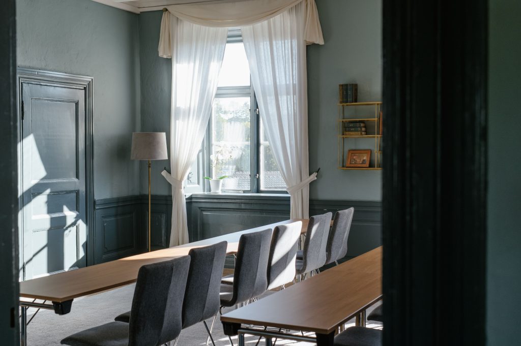 Konferensrum med l&aring;ngbord och stora f&ouml;nster i herrg&aring;rden